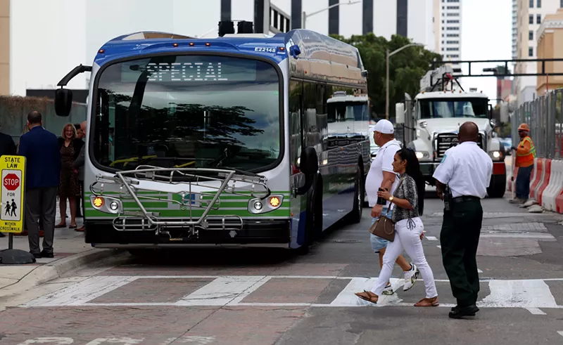 Image: Pedestrians walk past an electric bus on February 02, 2023 in Miami, Florida.