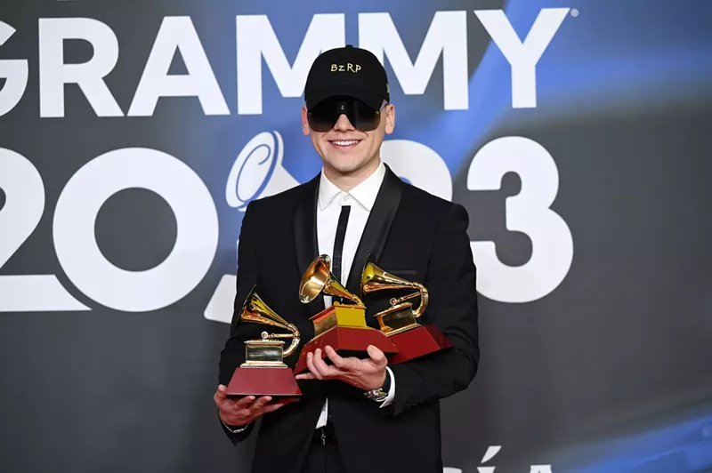 Image: Bizarrap posing with three Latin Grammy trophies in his hands