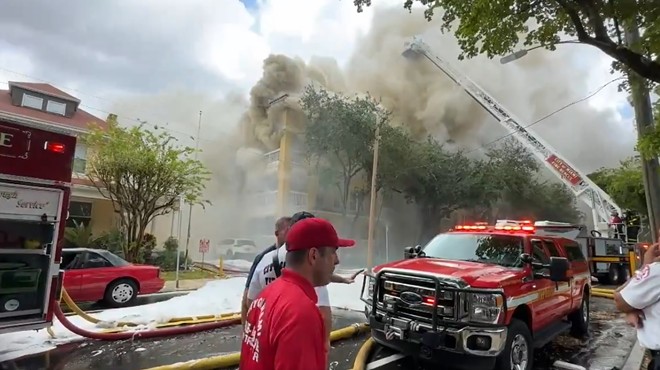 Smoke billows from the Temple Court Apartments in Miami as firefighters scramble to fight the blaze
