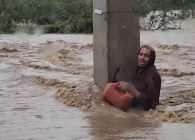 Image: A man clings to a concrete beam in Ponce, Puerto Rico, during flooding caused by Hurricane Fiona Sept. 17-18, 2022. He was rescued by members of the 125th Military Police Battalion.