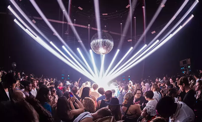 Image: laser lights, a disco ball, and a crowd