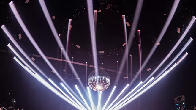 dancers dance on a dance floor underneath a disco ball