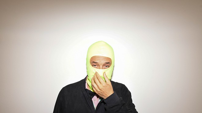 Harmony Korine, with his face covered by a neon-green balaclava