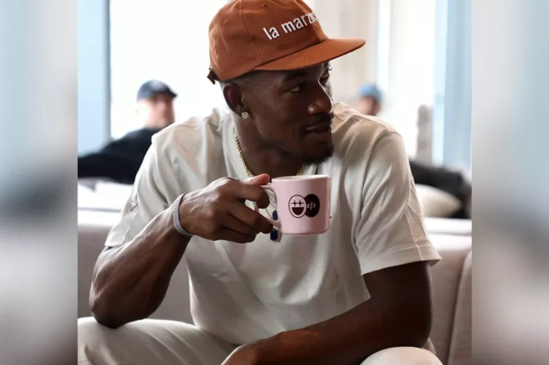 Image: Basketball star Jimmy Butler wearing a ballcap and drinking coffee out of a Bigface branded mug