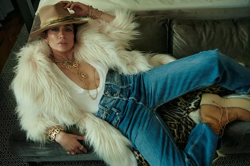 Image: Jennifer Lopez laying back in a white blouse and jeans