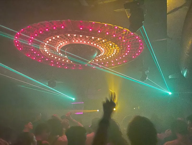 Image: The disco ball illuminates and partygoers throw their hands in the air