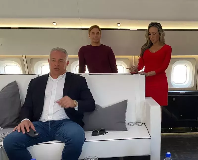 Image: John Ruiz (seated) aboard a private plane during a 2022 New Times interview.