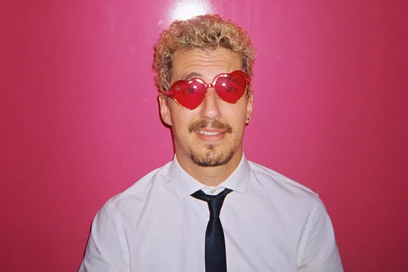 Image: Josch wears heart-shaped sunglasses standing against a bright pink background