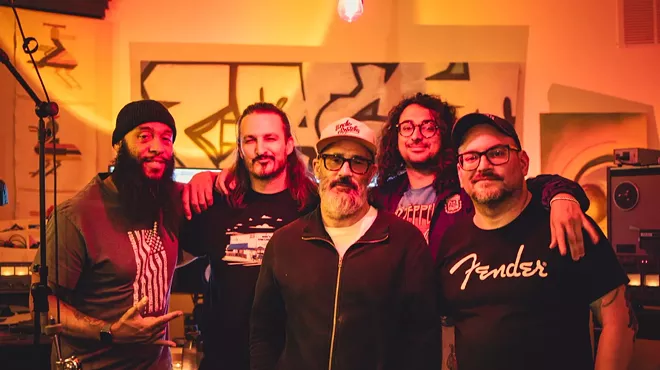 5 musicians posing for the camera.