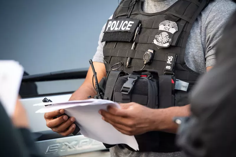 Image: An ICE agent checks paperwork.