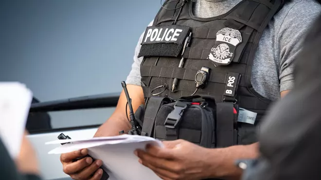 An ICE agent checks paperwork.
