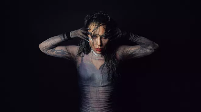 Photo of Lady gaga posing for the camaera with her hands on the side of her face.