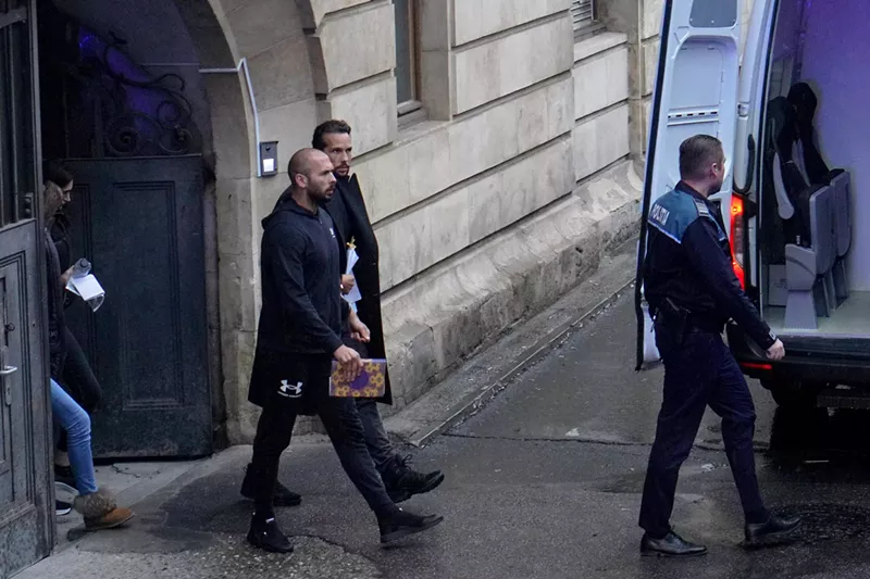 Image: Social media influencer Andrew Tate and his brother walk out of court in Romania