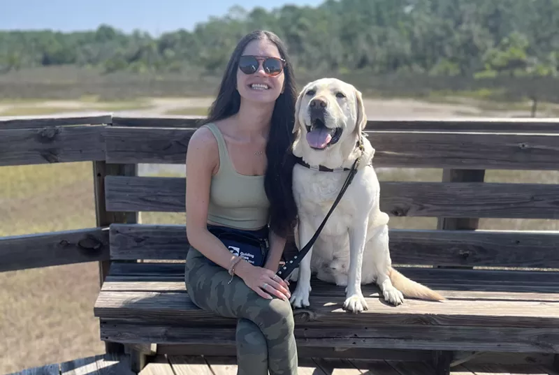 Image: Marin Baumer and her seeing-eye dog Kegan sitting on a bench