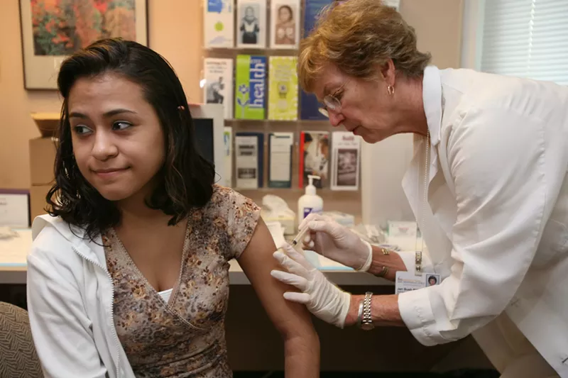 Image: A college student receives a vaccination at a clinic