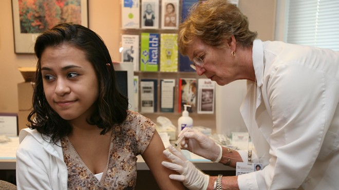 A college student receives a vaccination at a clinic