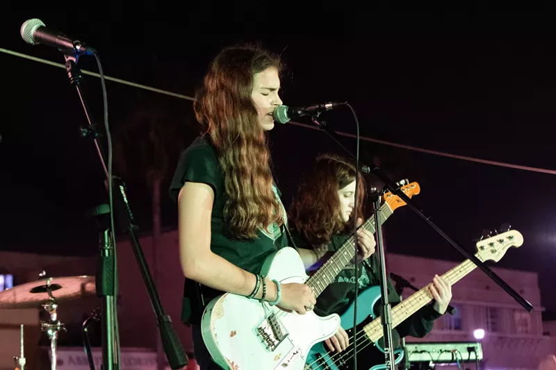 Image: Lily Kaplan performing on stage with a guitar