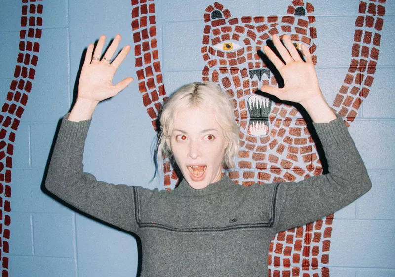 Image: Picture of a blonde woman with her hands up