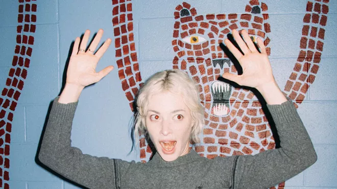 Picture of a blonde woman with her hands up