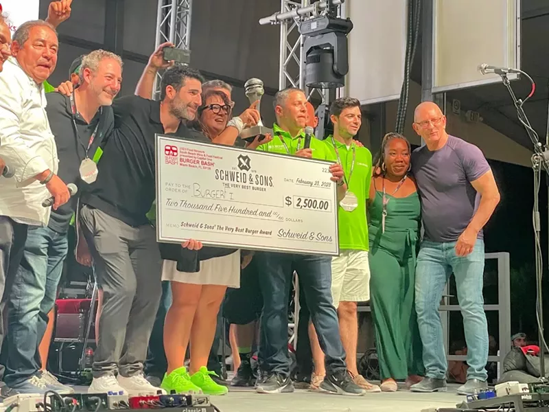 Image: Emeril Lagasse and Robert Irvine present the Very Best Burger award to BurgerFi at the 2023 Burger Bash.