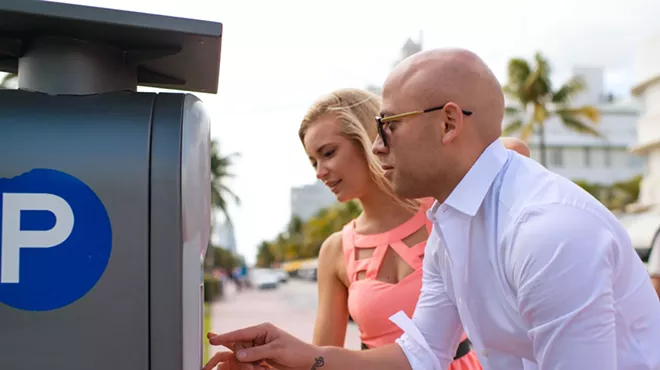 A woman and a man pay at a Pay by Phone meter in Miami Beach