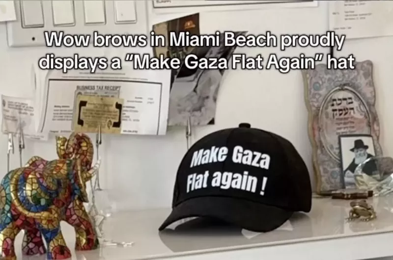 Image: A black hat with the text "Make Gaza flat Again!" sits on a counter inside a salon