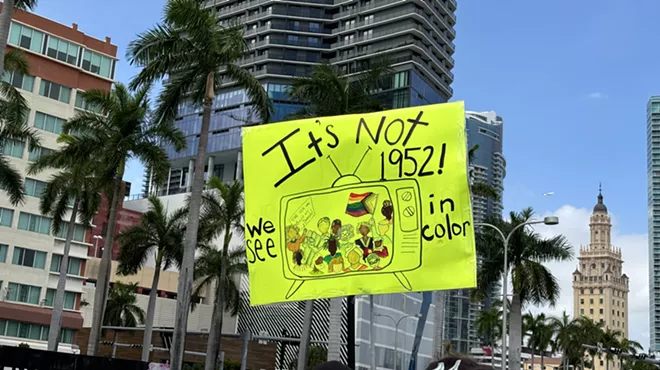 A sign at a protest states, "It's not 1952. We see in color."