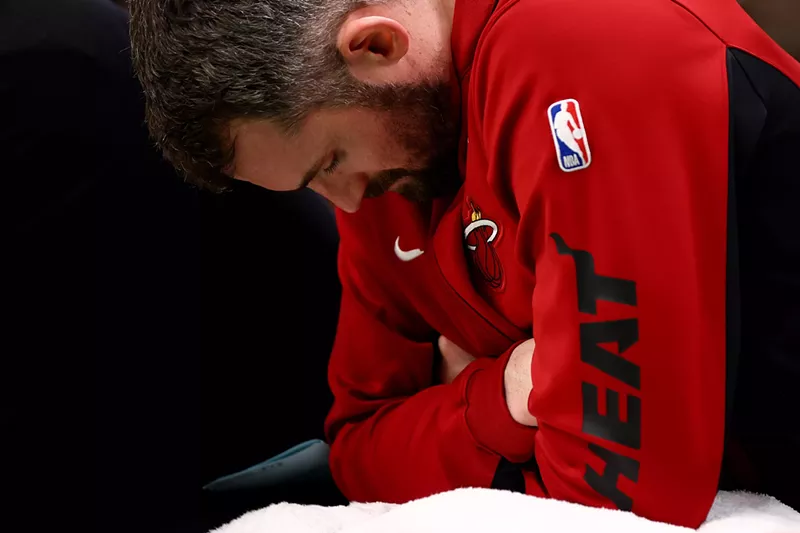 Image: Miami Heat player Kevin Love stares down toward the floor from the bench during a playoff game