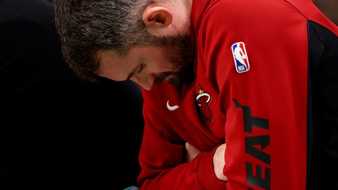 Miami Heat player Kevin Love stares down toward the floor from the bench during a playoff game