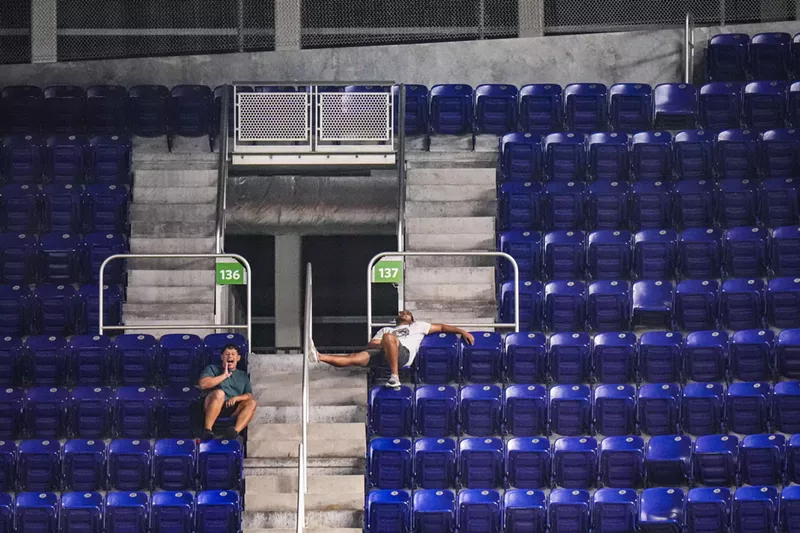 Image: Two fans at the Miami Marlins' stadium in a sea of empty seats