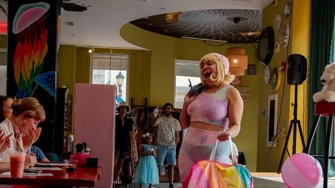 A woman performs in front of judges at a Barbie-themed fashion show