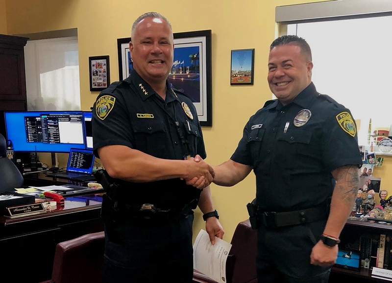 FIU Police Chief Alexander Casas (left) shakes hands with police officer Yesid Ortiz during a ceremony to swear in Ortiz.