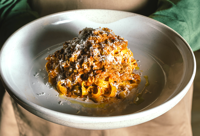 Image: a meat pasta with cheese shavings