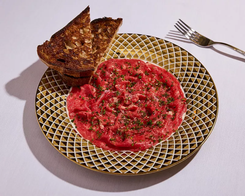 Image: steak tartare in a ceramic serving dish with a side of toasted bread