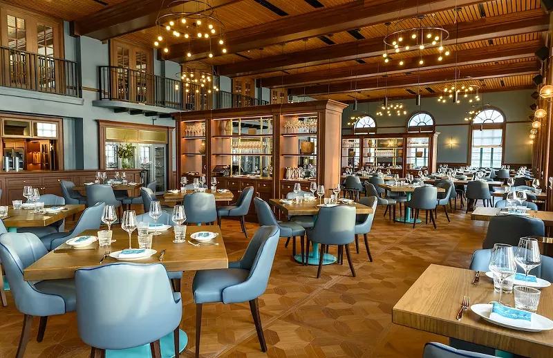 Image: A dining room with blue seats and golden chandeliers