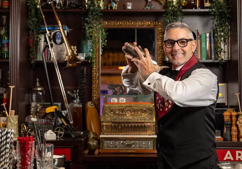 Image: man behind bar shaking cocktail