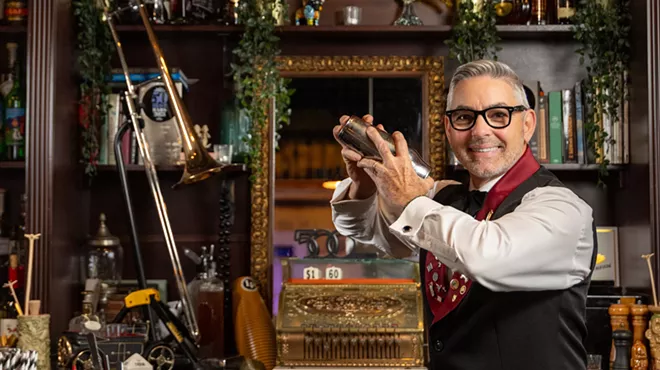 man behind bar shaking cocktail