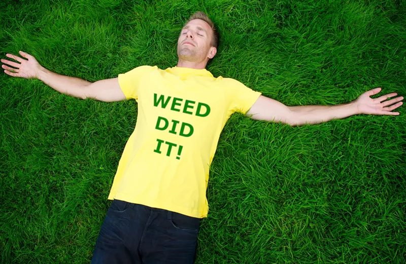 Image: Man laying on grace with yellow shirt that reads,"Weed did it!"