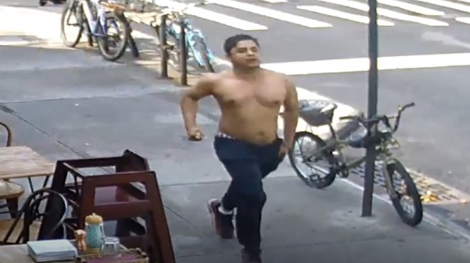 A shirtless man runs desperately through the streets of New York City