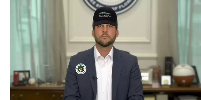 Image: Florida Attorney General James Uthmeier wearing an alligator alcatraz hat and an alligator alcatraz button