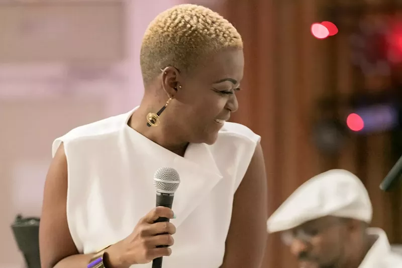 Image: LaVie holding a microphone while performing onstage