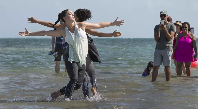 Image: Dancers in the water while an audience watches