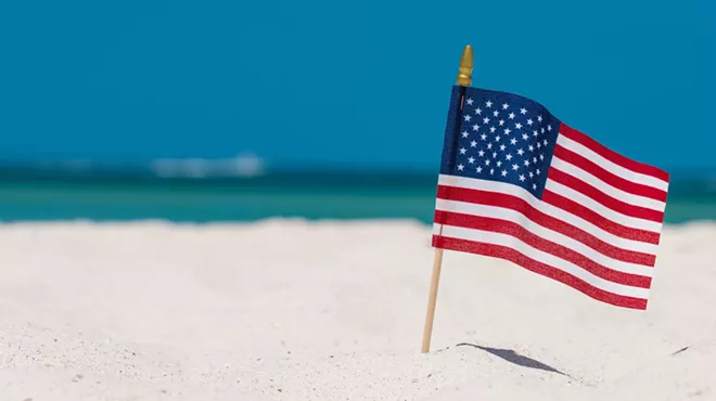 a small flag on a stake on a tropical beach