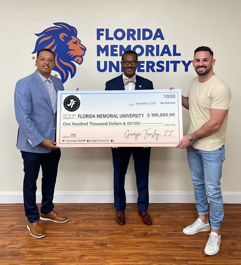 Image: Florida Memorial University (FMU) president Jaffus Hardrick and George Trosley III pose with an oversized check to FMU.