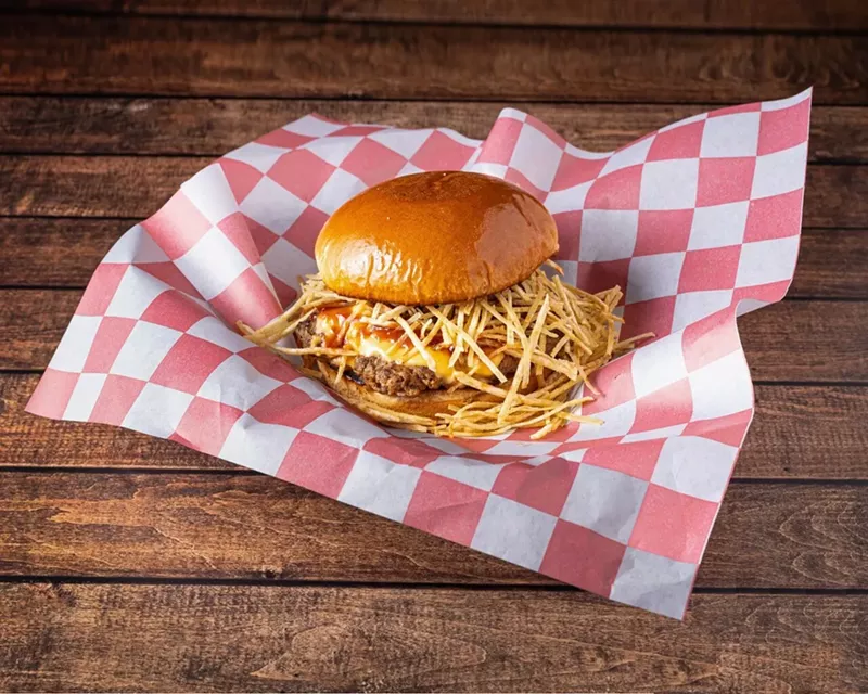Image: A burger with fries on red and white wax paper