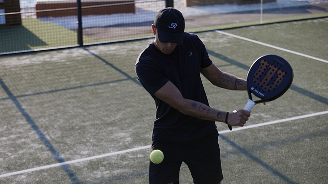 A man playing hitting a ball with a padel racket