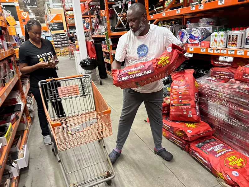 Image: A man grabs a bag of charcoal at the North Miami Home Depot