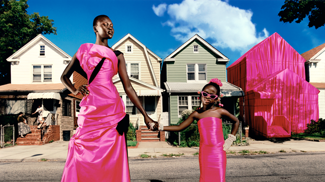 Black woman and child posing on the street in hot-pink dresses