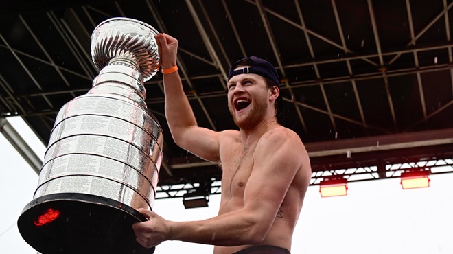 A shirtless Steven Lorentz holding the Stanley Cup trophy
