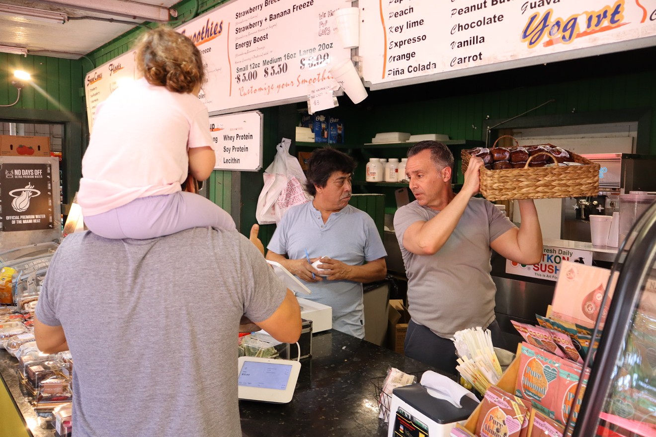The owner of Pinecrest Wayside Market Eli Tako (pictured right) tends to his customers as he loves to do.